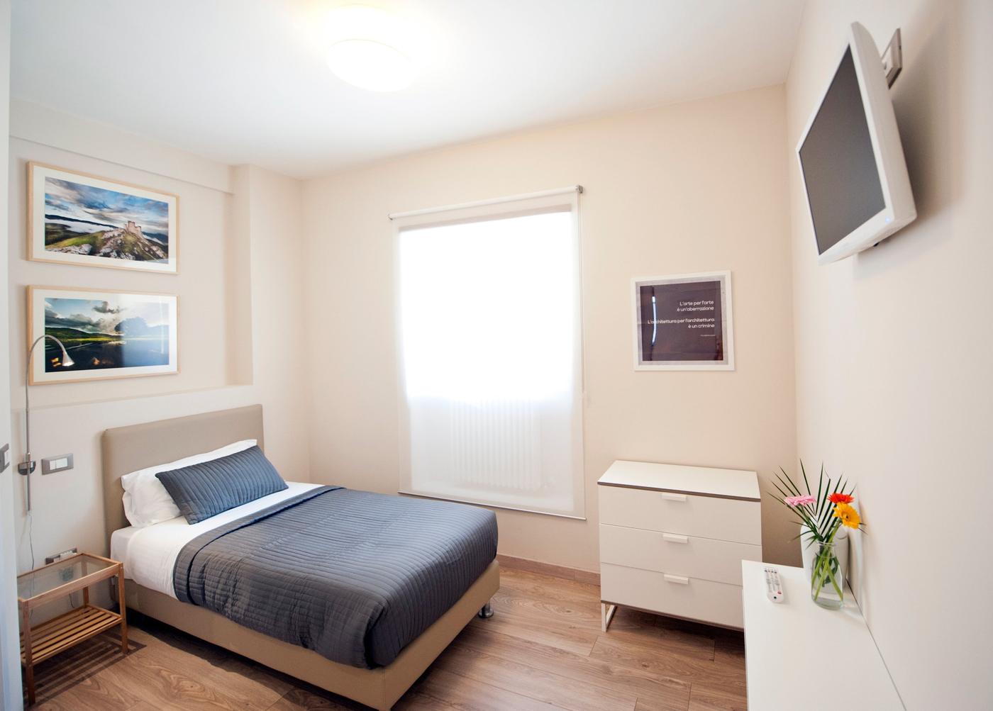 Camera singola con letto e fotografie alle pareti